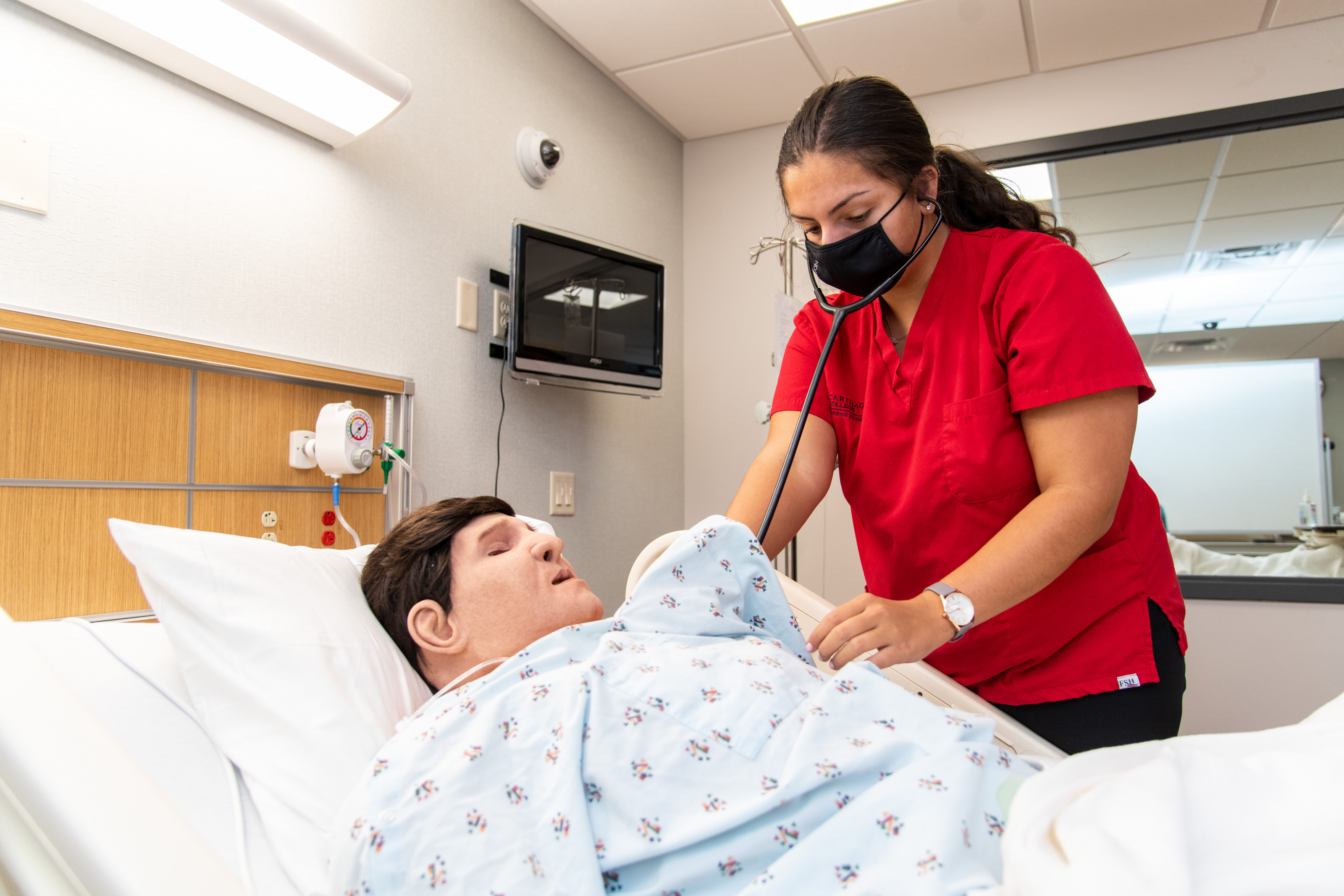 A nursing major practices skills in the nursing lab.