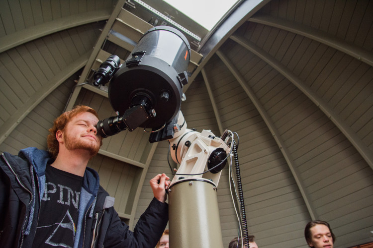A Carthage College student uses a telescope during an astronomy course field trip to an observato...