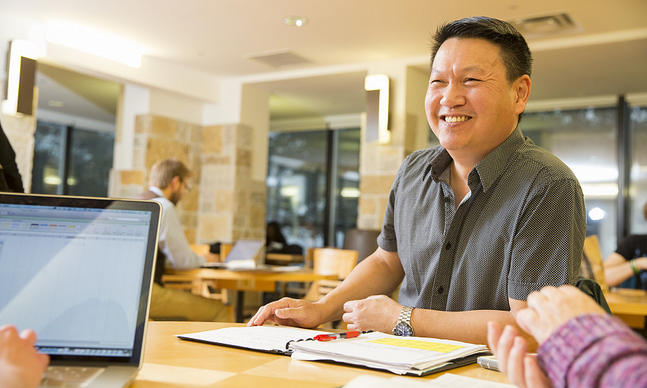 A graduate student studies with fellow students in Hedberg Library.