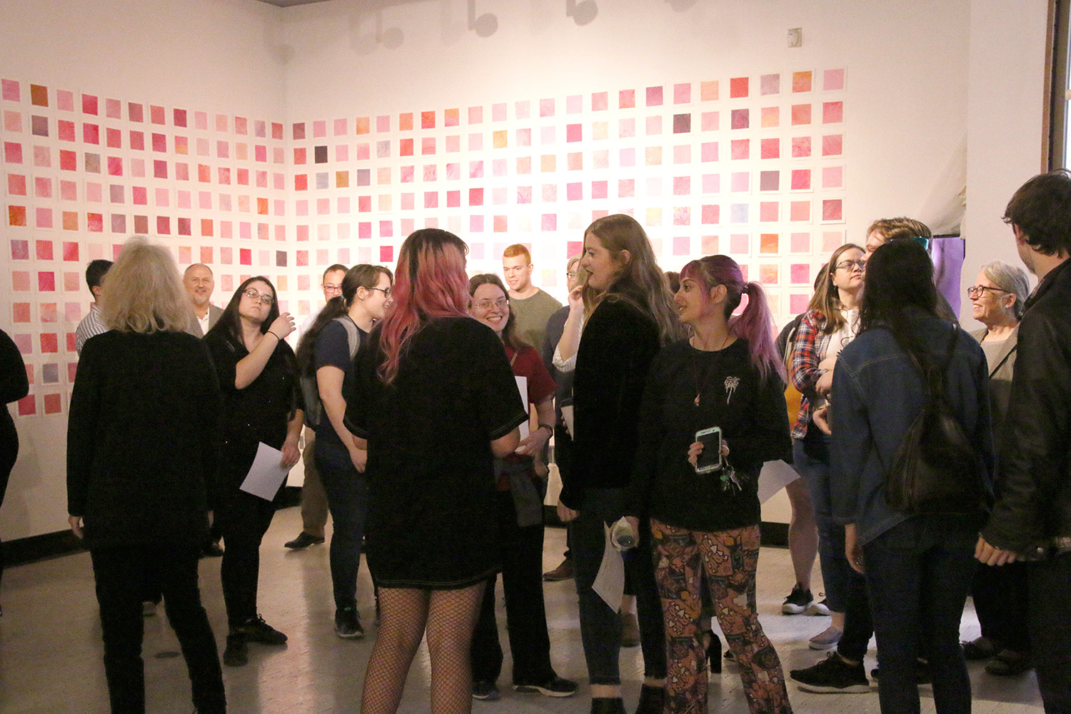 Students and visitors at a Spring 2019 Senior Thesis Opening. (in the background, paintings by Haley Schrock '19)