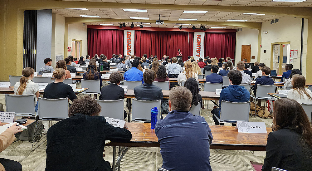 Students sitting at long tables in rows.