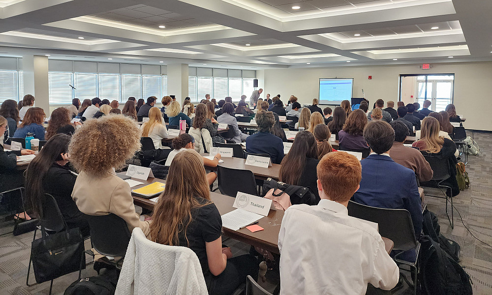 Students sitting in rows of long tables.