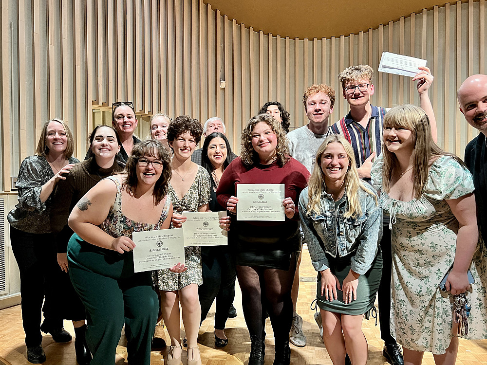 A group of Music students and faculty show off certificates while posing for a picture