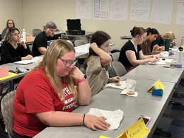 Students in a classroom sitting at long tables.