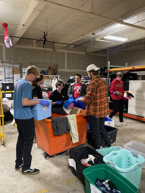 Students sorting through a bin of winter clothing.