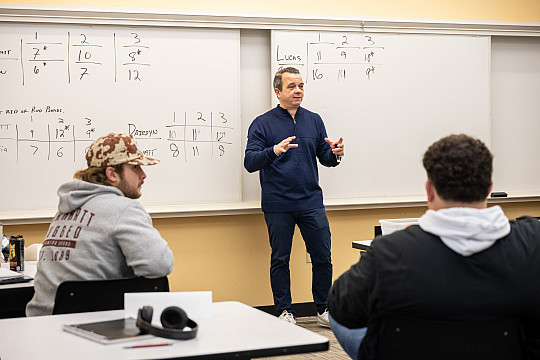 Professor Joseph Tenuta teaching students in the classroom.