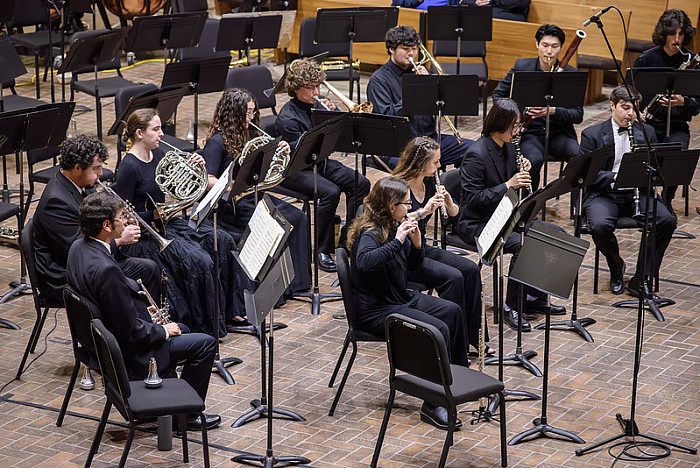 Students performing multiple instruments as part of a Wind Orchestra event.