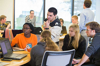 Students pursuing a computer science major in a classroom.