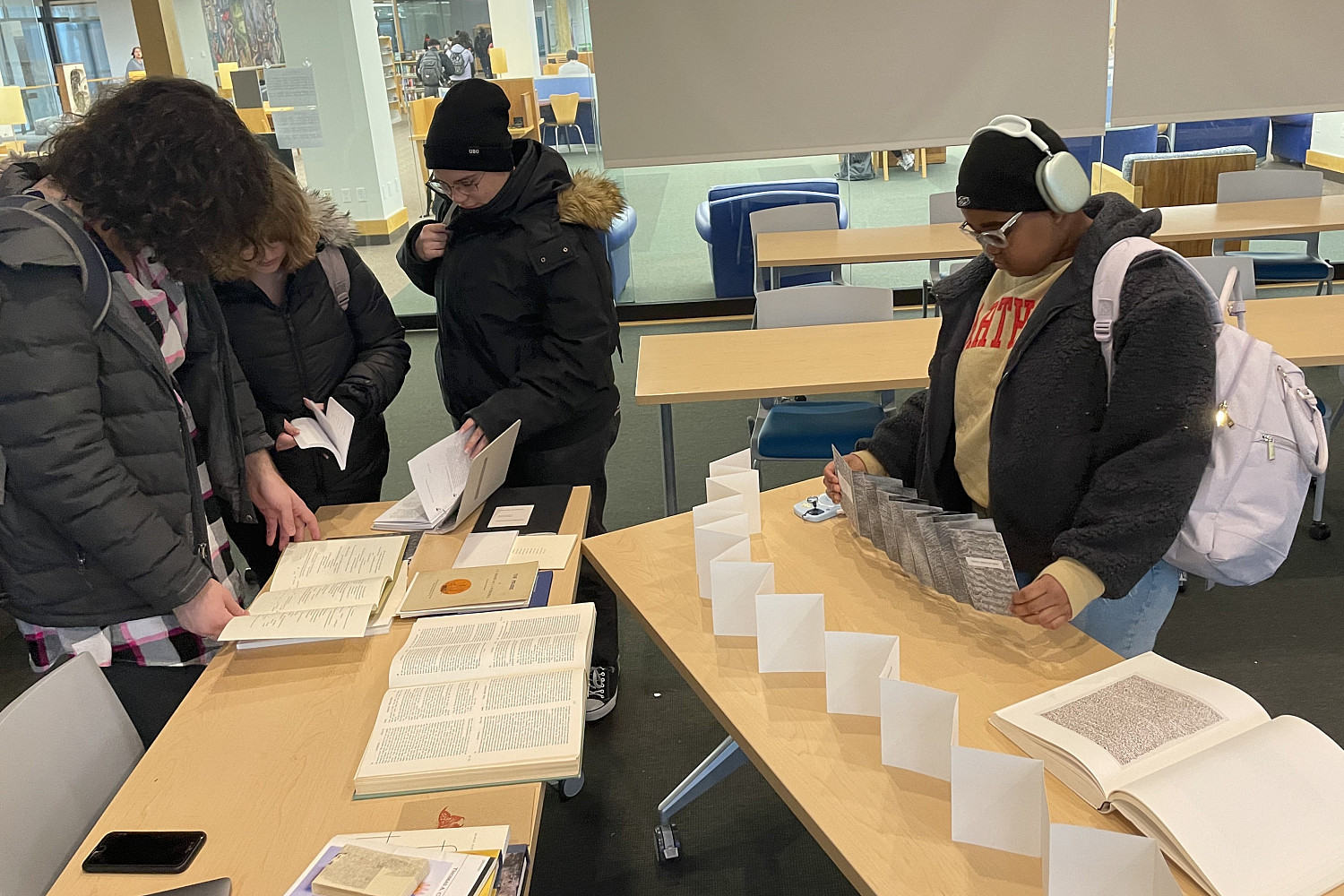 Students viewing books made by visiting writer, bookmaker, and publisher Jordan Dunn.