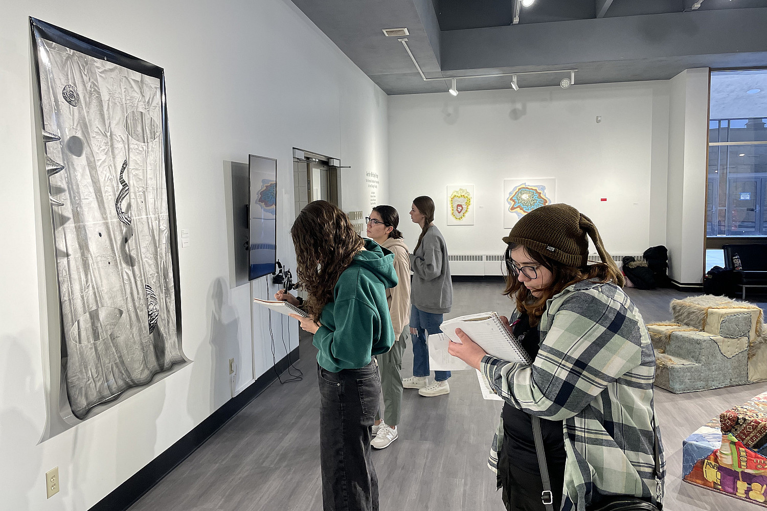 Creative writing students finding inspiration at an on-campus art gallery exhibit.