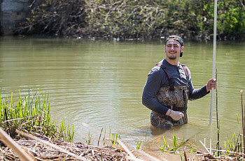 Student collecting samples from the Pike River.