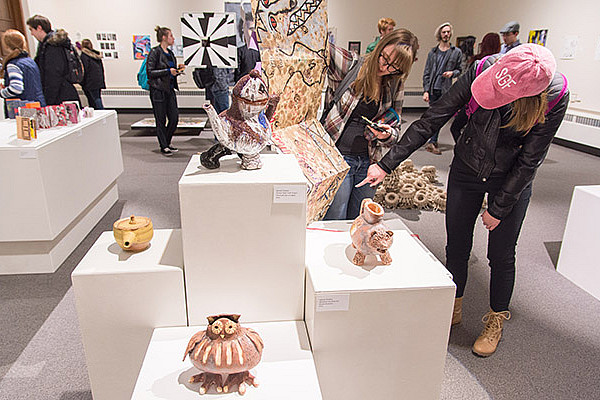 Patrons view artwork in an exhibit in the H. F. Johnson Gallery of Arts.