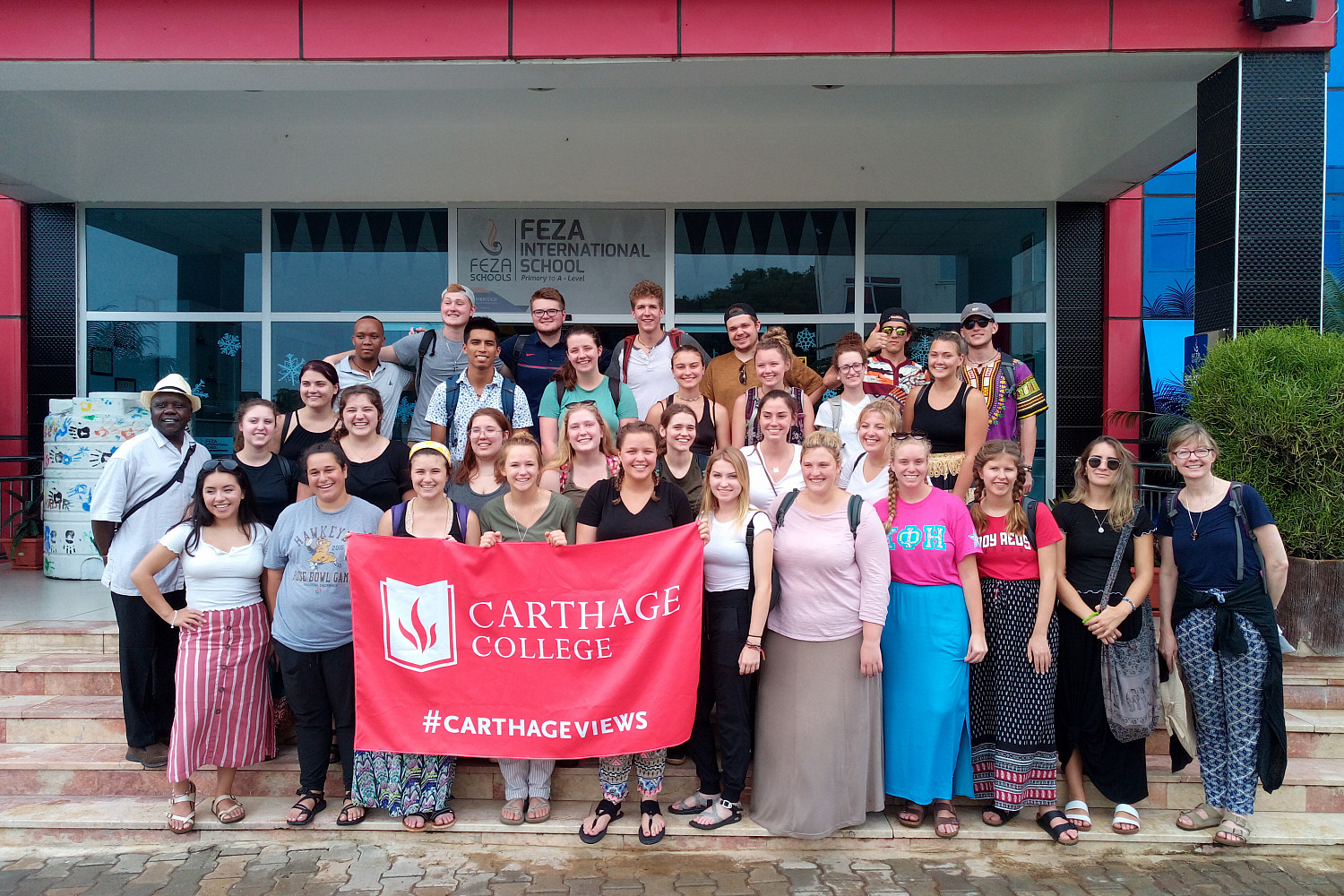 A group photo of students in front of FEZA International School on the study tour to Tanzania.