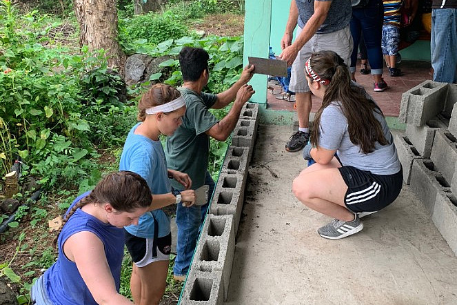 Students helping build a structure.