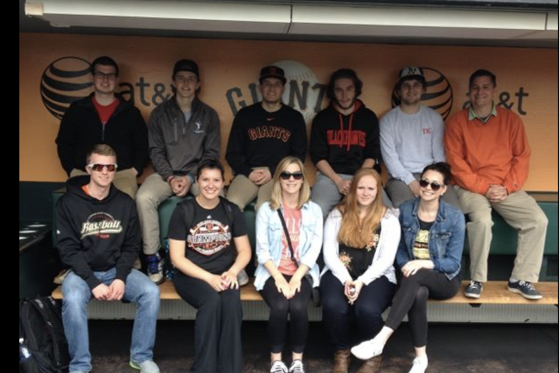 Students sitting in the San Francisco Giants dugout.