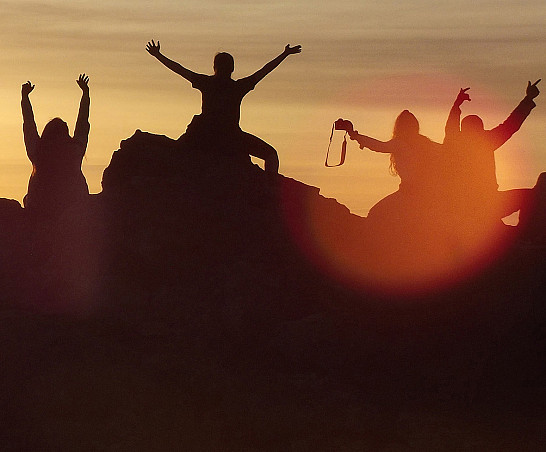 Students watch the sunset on top of a cliff during a J-Term study tour.