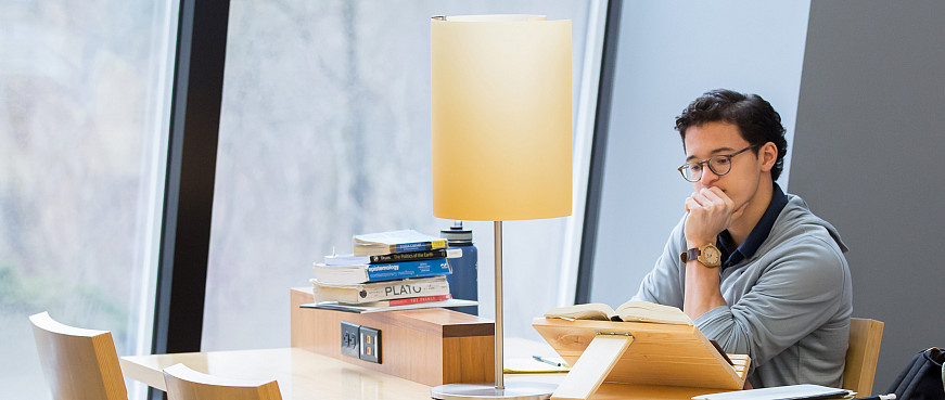 A student reads in Hedberg Library.