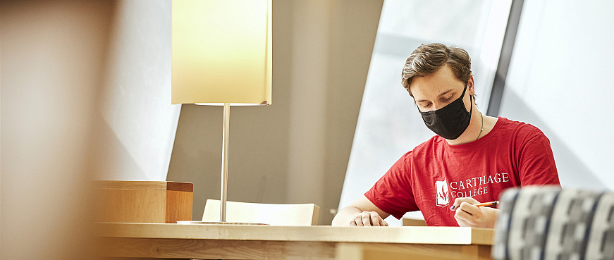 A student reading in Hedberg Library.