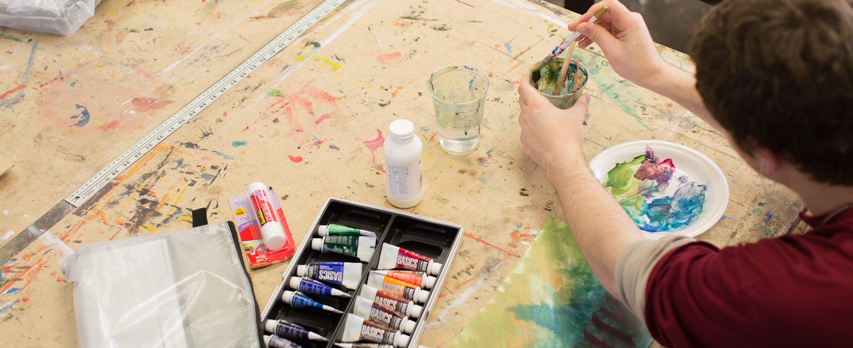 Prof. Diane Levesque demonstrates painting techniques to her class.