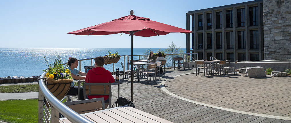 Students enjoy the nice weather and Lake Michigan view from the Straz patio.