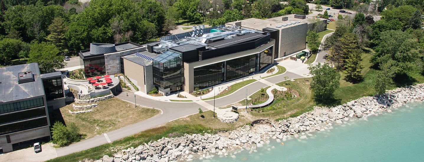 A student sitting at a table on a patio overlooking Lake Michigan.