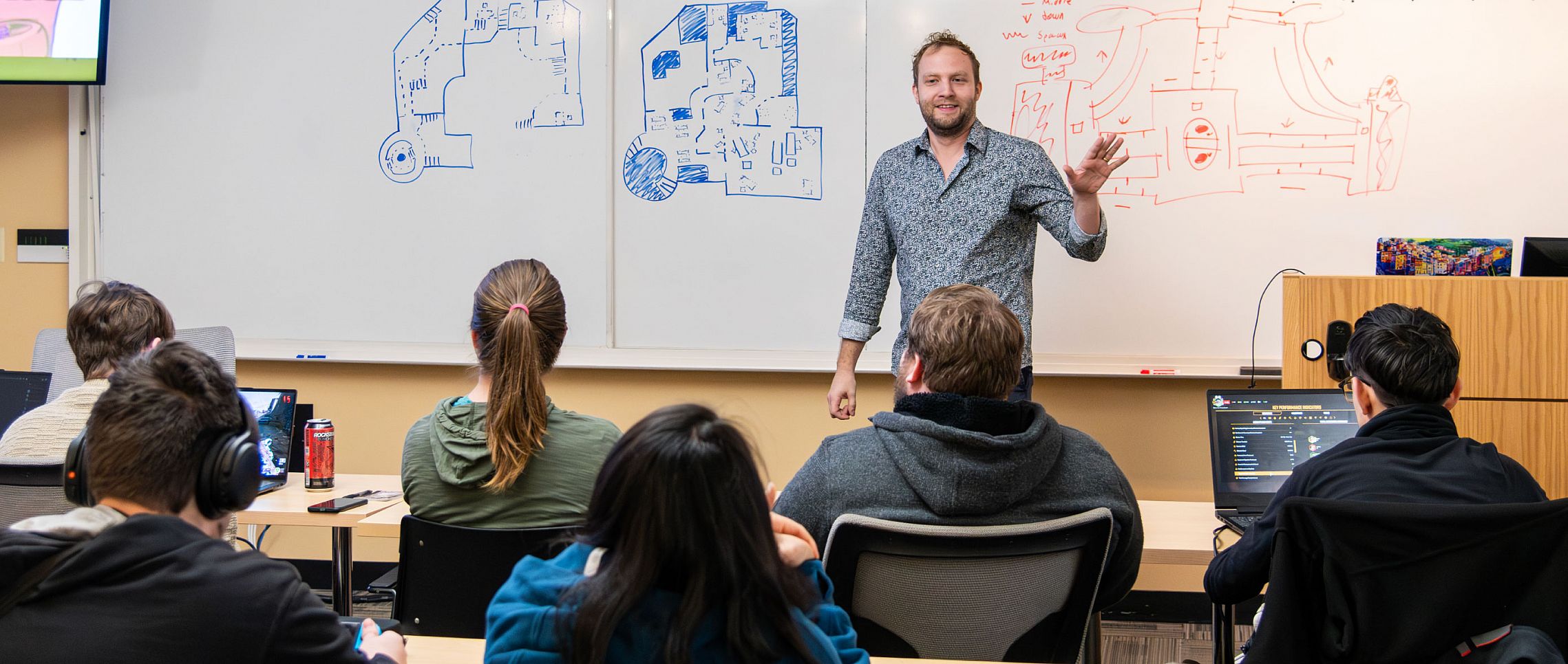 A computer science professor in front of a classroom of students.