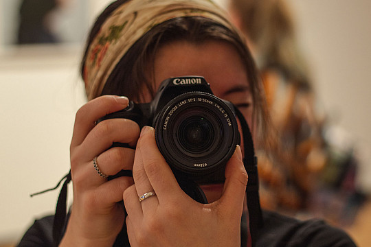 A Carthage College's photography major using a camera.