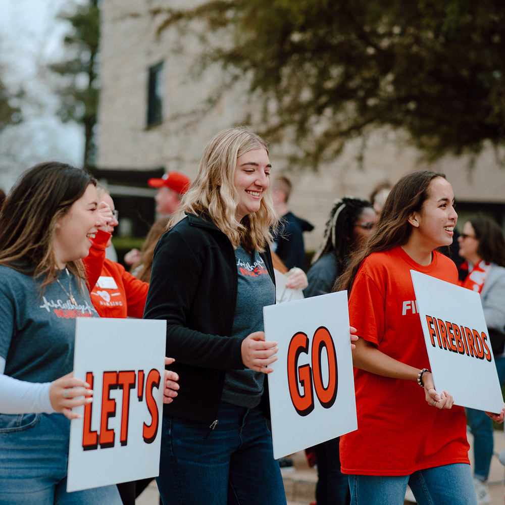 ?Let's Go, Firebirds!? Students walk in the Homecoming Parade.