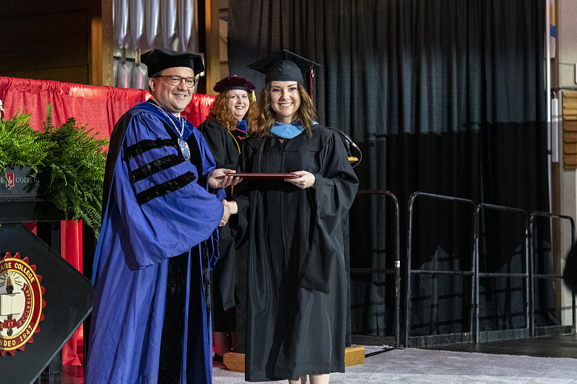A graduate receives her diploma from President Swallow. 